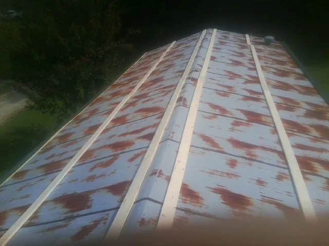 Rusted metal roof panels with new wood purlins before replacement — Storm Damage Roof Repair in Minong by Roofing Brothers