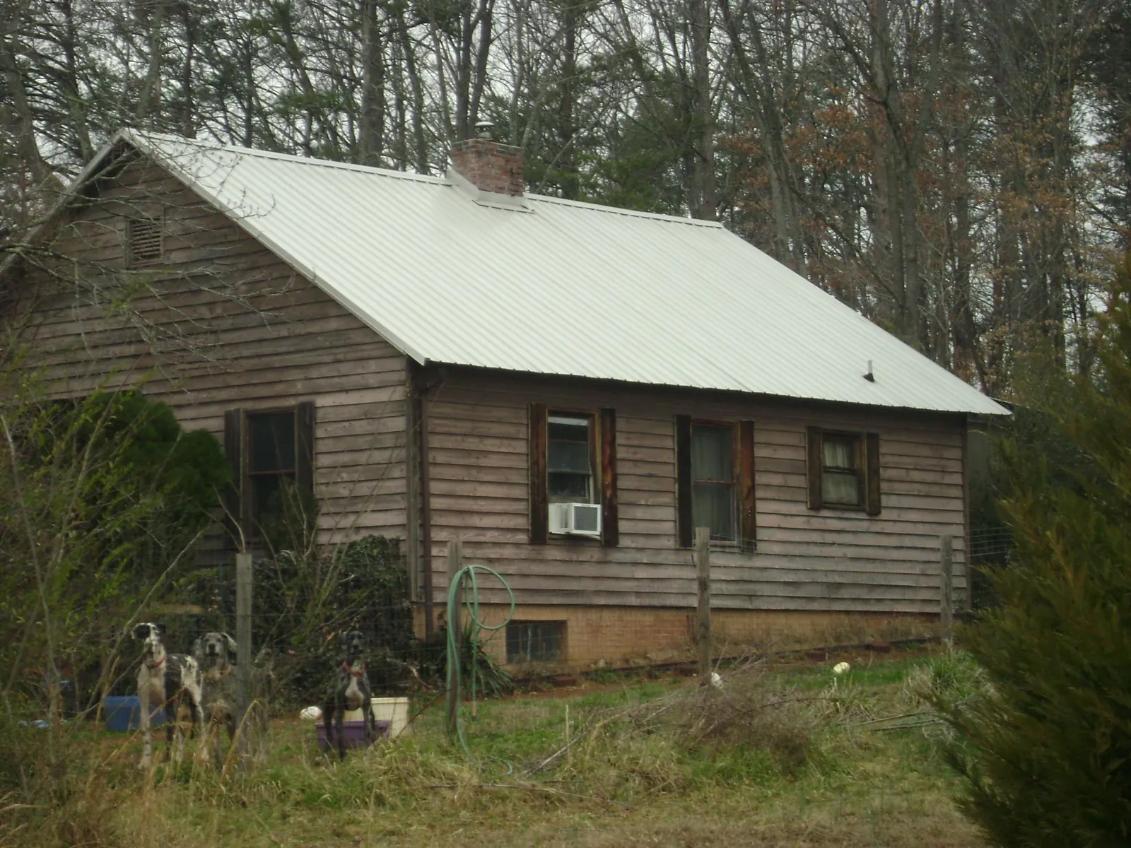 White metal roof on an old wood sided farmhouse, from a Metal Roof Installation job in Minong